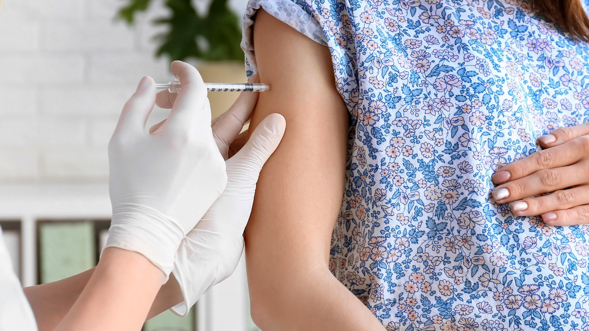 Frau erhält Impfung in den Oberarm