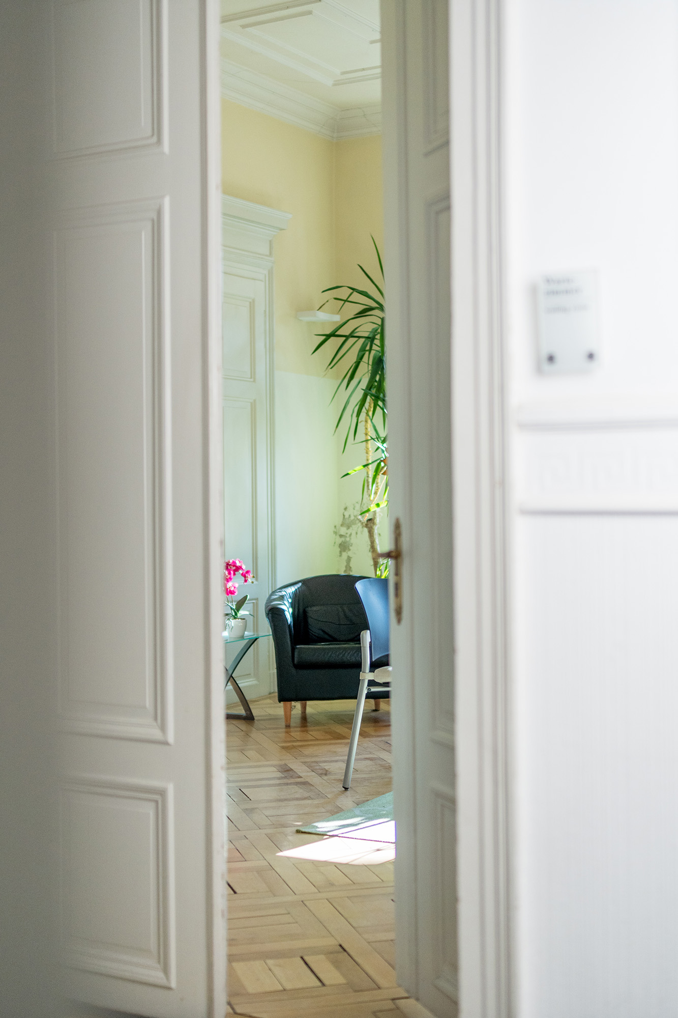 Blick ins Wartezimmer durch halb geöffnete Tür Blick ins Wartezimmer durch halb geöffnete Tür